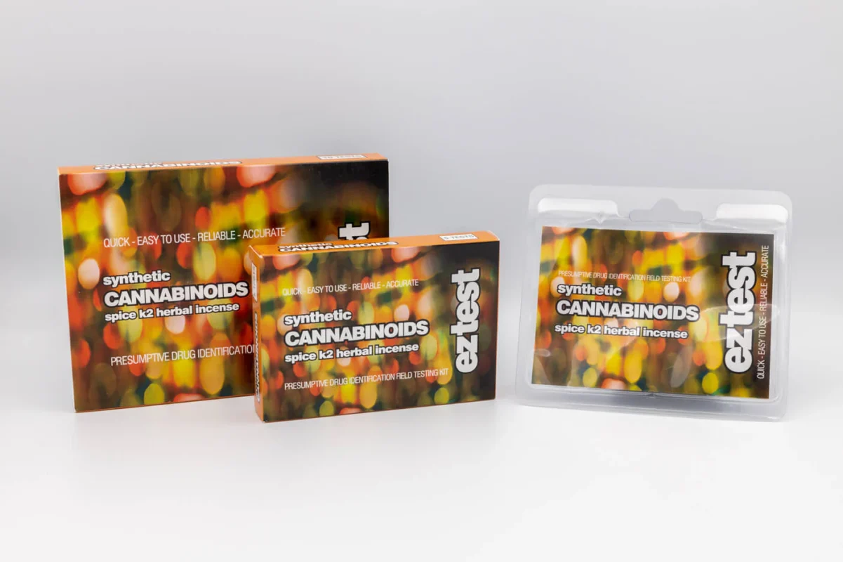 Synthetic cannabinoids K2 Spice, K2 Spray, and K2 Paper with warning signs for health risks and addiction.